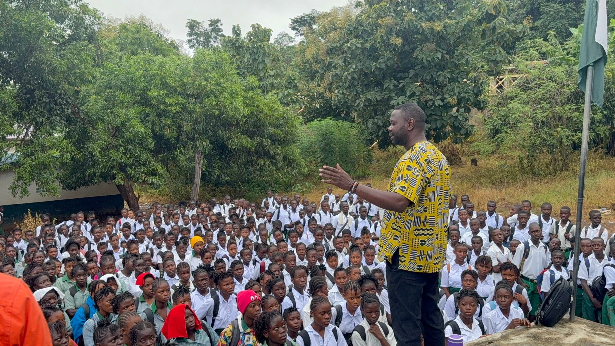 Addressing students at a school assembly.